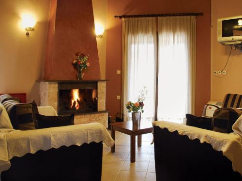 a living room with two couches and a fireplace at Karyon Apartments in Kariófiton