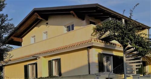 Una casa amarilla con un árbol delante. en Soggiornare a Cagliari en Cagliari