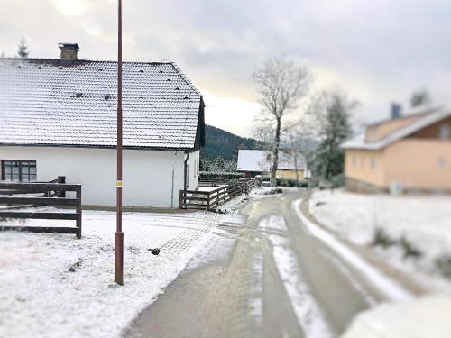 a snow covered street with a building and a house at Kubovka 63 in Kubova Huť