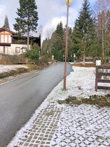 a road with snow on the ground and a street light at Kubovka 63 in Kubova Huť