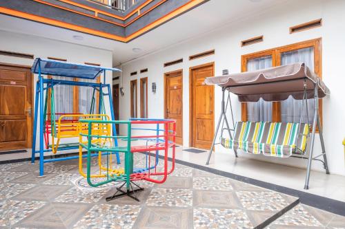 a room with colorful chairs and a swing at Urbanview Hotel One Family Maribaya by RedDoorz in Lembang