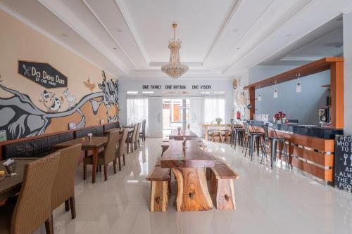 a restaurant with wooden tables and chairs and a bar at Urbanview Hotel One Family Maribaya by RedDoorz in Lembang