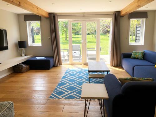 a living room with a blue couch and a blue rug at The Cottages at Crouchers Orchards in Chichester