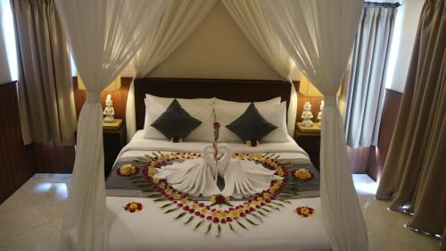 a bedroom with a bed with a flower arrangement on it at Villa D'Uma in Ubud
