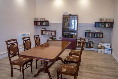 a dining room with a wooden table and chairs at Stone Art Guest House & Camping in Pemzashen