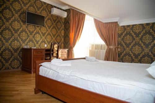 a bedroom with a large bed and a window at Complex Zolota Pidkova in Zolochiv