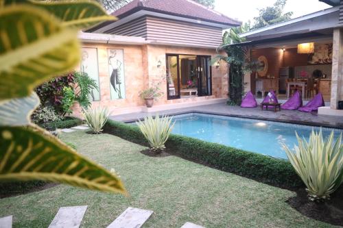 a swimming pool in the yard of a house at Villa D'Uma in Ubud