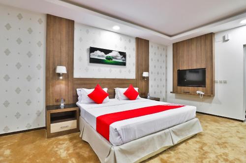 a large bedroom with a large bed with red pillows at نجمة نوارة للوحدات الفندقية in Najran