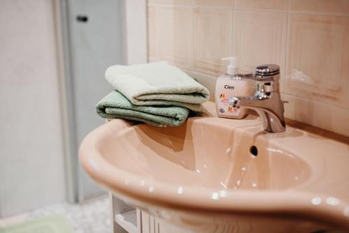 La salle de bains est pourvue d'un lavabo, de serviettes et d'un miroir. dans l'établissement Ferienwohnung Hartlieb Goldeck Millstättersee, à Spittal an der Drau