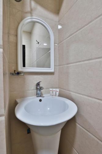 a bathroom with a white sink and a mirror at شقق نجمة نوارة للشقق المخدومة - إقتصادي - Najmat Nawara For Serviced Apartments - Economy in Najran