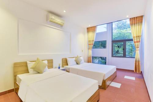 - une chambre avec 2 lits et une grande fenêtre dans l'établissement Annie Danang Hotel & Apartment, à Đà Nẵng