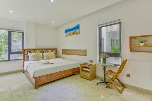a bedroom with a bed and a desk in it at Annie Danang Hotel & Apartment in Danang