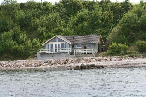 a house on the shore of a body of water at Loff Holiday Houses in Aabenraa