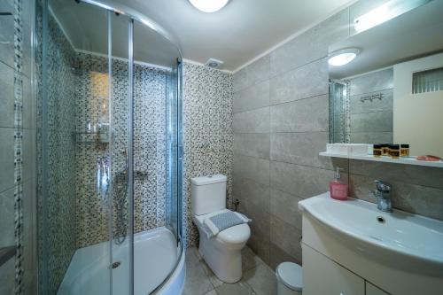 y baño con ducha, aseo y lavamanos. en City Center Apartment Project, en Heraclión