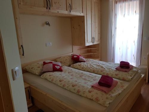 2 camas en un dormitorio con almohadas rojas. en Guest house Pr Ambružarju & Apartments, en Cerklje na Gorenjskem