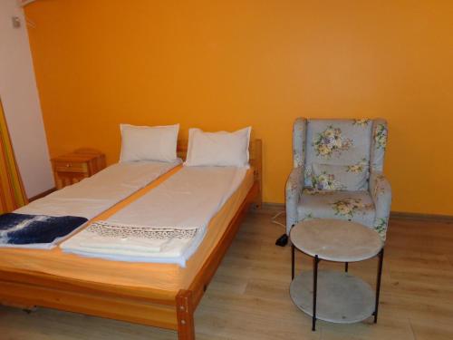 a bedroom with a bed and a chair at Apartment Moni in Veliko Tŭrnovo