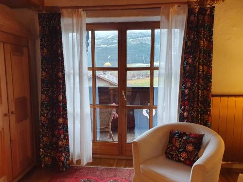 a living room with a chair and a window at Appartement Pension Bäckenhäusl FERIENWOHNUNGEN Chalets Hütten Komfortzimmer in Uttendorf