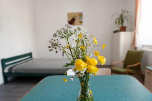 a vase filled with yellow and white flowers on a table at Apartmány16 Olešnice v Orlických horách in Olešnice v Orlických horách