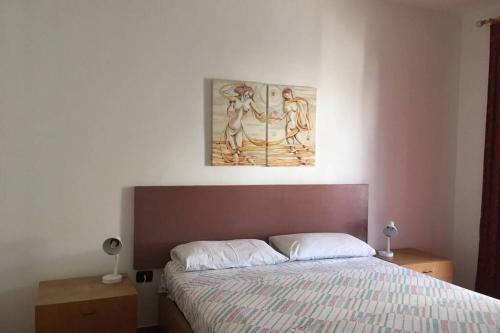 um quarto com uma cama e um quadro na parede em Rosato apARTment in Porto Cesareo em Porto Cesareo