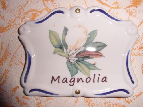 a plate with a magnolia on it on a wall at Agriturismo La Dimora Del Contadino in Mondovì