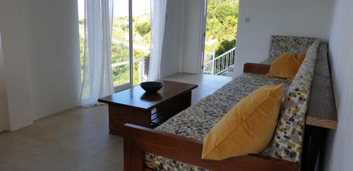 a room with a couch and a table and a balcony at Evie Cottage in Bioche