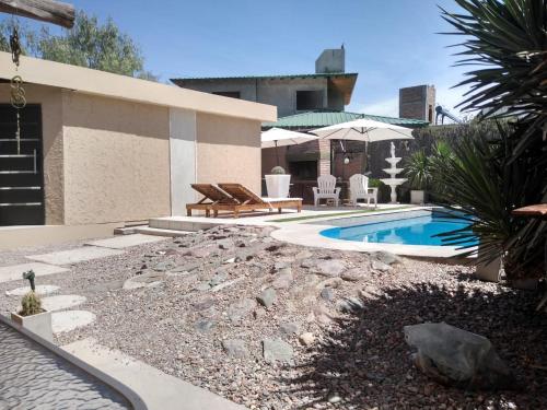 un patio trasero con piscina y una casa en Posada El Alamo Mendoza en Mendoza