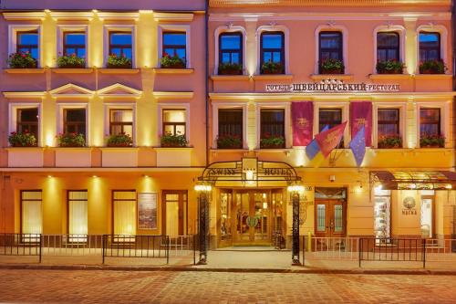 a building on a city street at night at Swiss Hotel in Lviv
