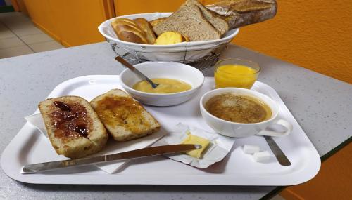 a plate of food with bread and a bowl of soup at Premiere Classe Limoges Nord in Limoges