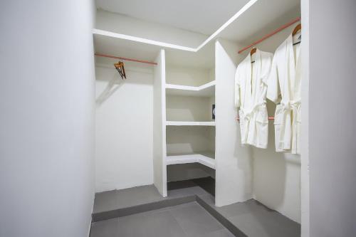 a walk in closet with white clothes on racks at Hotel Boutique Casa Xaan in Valladolid