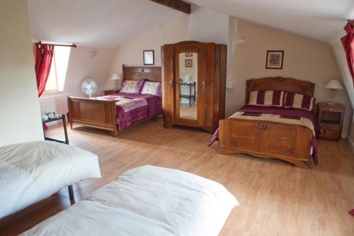 a bedroom with two beds and a mirror at L'Ancien Presbytère Chambres D'hote ou Gite in Le Dorat