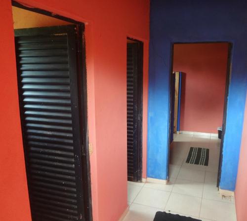a room with red and blue walls and two doors at Camping do Delei in São Thomé das Letras