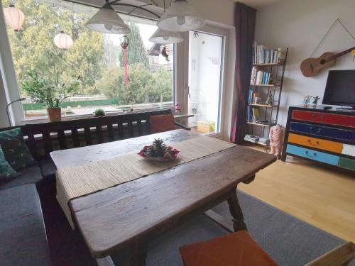 einen Holztisch im Wohnzimmer mit einem großen Fenster in der Unterkunft Gartenblick in Mittenwald