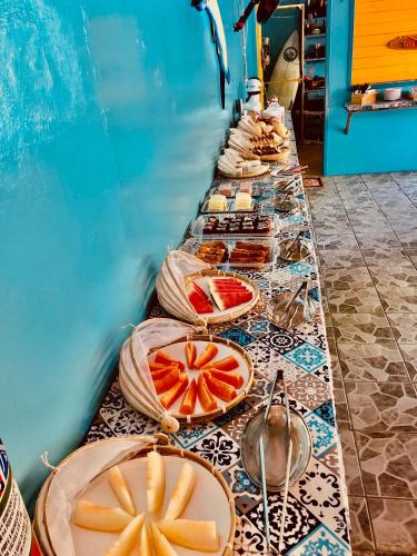 a buffet line with plates of food on a table at Pousada & Camping Tubarão in Ilha do Mel