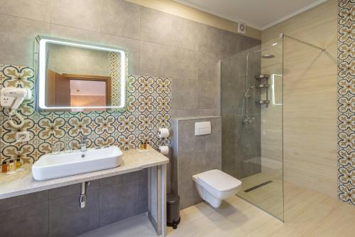 La salle de bains est pourvue d'un lavabo, d'une douche et de toilettes. dans l'établissement Mal'ovanka, à Bukovel