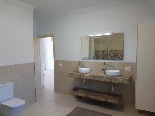 uma casa de banho com 2 lavatórios e um espelho em Casa Solanum em Frigiliana