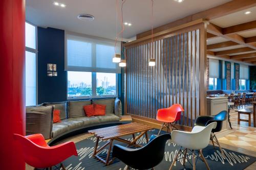 a living room with a couch and chairs and a table at ibis Sorocaba in Sorocaba