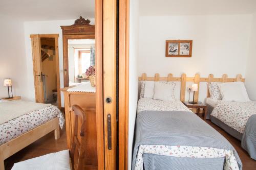 a bedroom with two twin beds and a mirror at Hotel Funivia in Courmayeur
