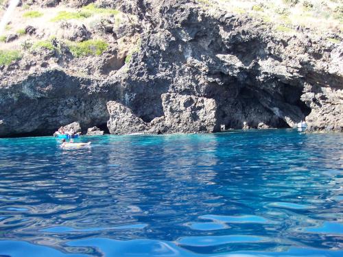 a person swimming in the water next to a cliff at Residence Timeo in Ustica