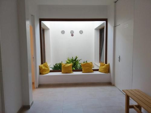 a hallway with yellow pillows on a window sill at Apartamentos Villa Primera in Cala Figuera