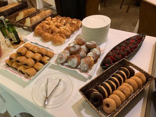 a table with different types of pastries and trays of donuts at Aparthotel Siente Boí & SPA in Pla de l'Ermita
