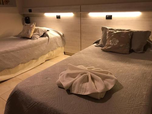 a bedroom with two beds with towels on them at Hotel Los Naranjos in General Deheza