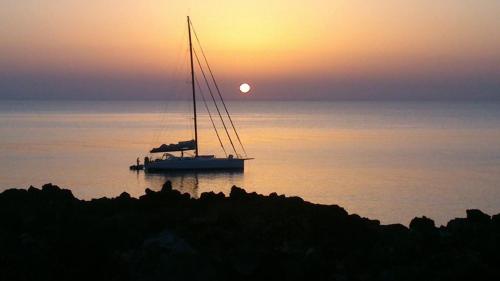 a sail boat in the water at sunset at Residence Timeo in Ustica