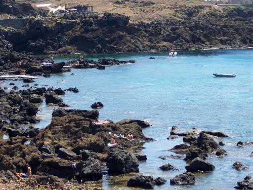 a group of people laying on the rocks on a beach at Residence Timeo in Ustica