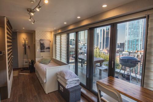 a bedroom with a bed and a balcony with a table at Myeongdong Artmonstay in Seoul