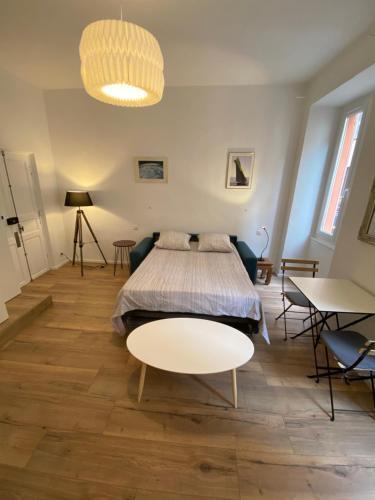 um quarto com uma cama e uma mesa em STUDIO rue pietonne Ajaccio em Ajaccio