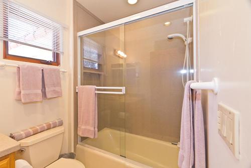 een badkamer met een douche en een glazen deur bij Custom Mediterranean-Style Santa Barbara Apartment in Carpinteria