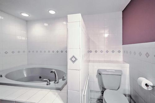 a bathroom with a tub and a toilet and a sink at Cozy A-Frame Center Barnstead House on Locke Lake! in Barnstead