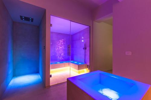 a purple bathroom with a tub and a shower at Seebay Hotel in Portonovo
