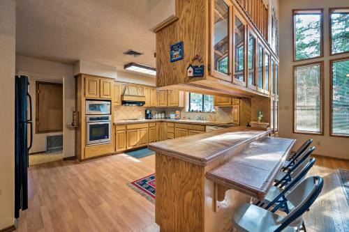 a large kitchen with wooden cabinets and a counter top at Cloudcroft Mtn Home with Patio, Walk to Golf Course! in Cloudcroft