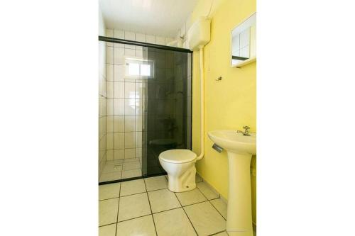 y baño con ducha, aseo y lavamanos. en Apart 200m da praia, estacionamento, A/C, en Florianópolis